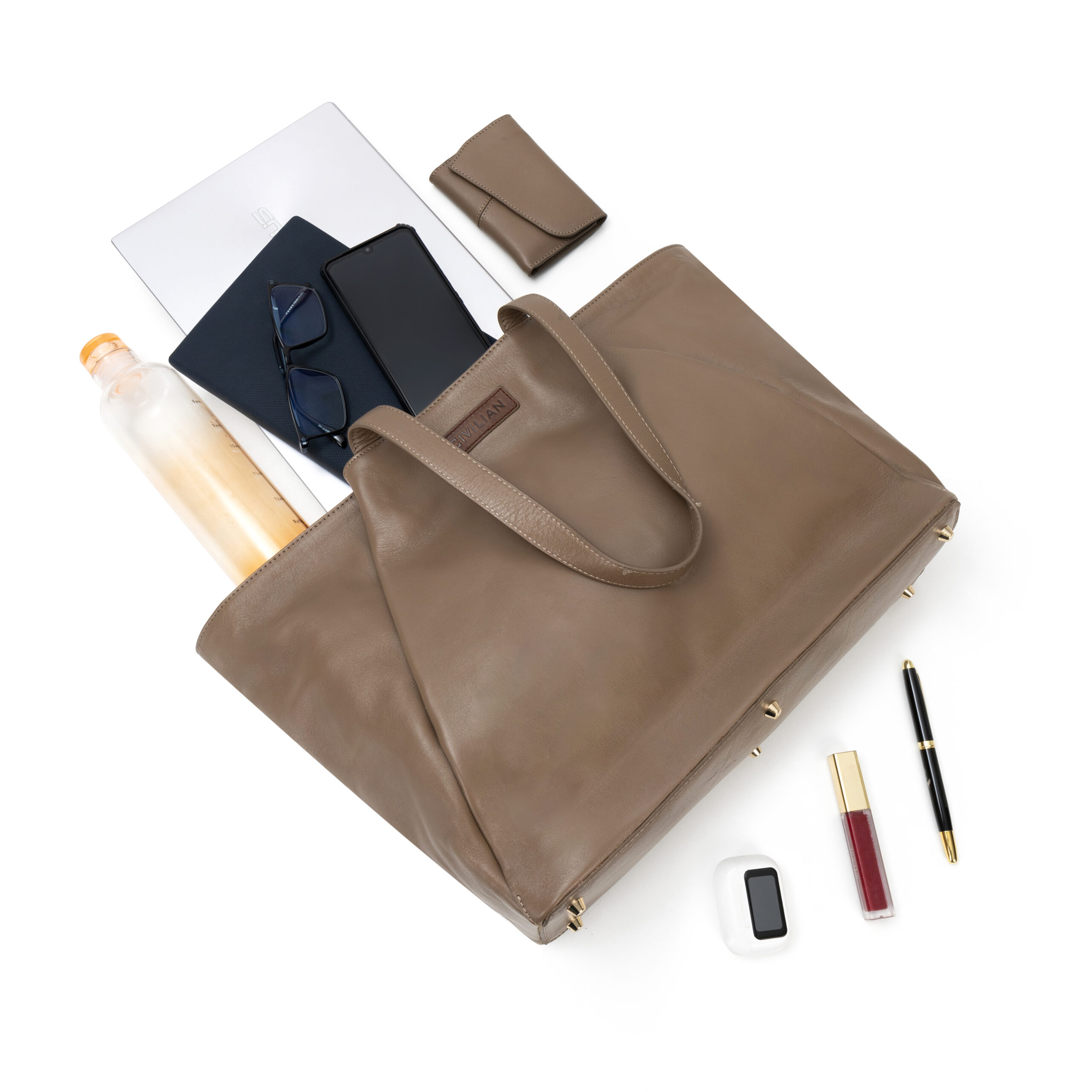 Inside of luxury leather tote with laptop, wallet, and accessories.